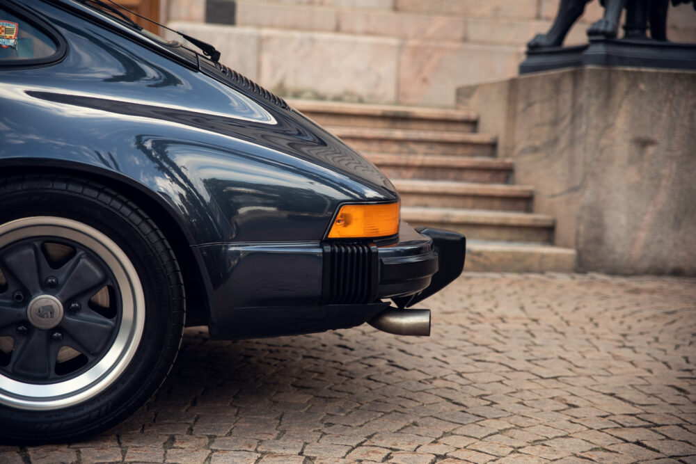 Vintage black Porsche rear view on cobblestone street