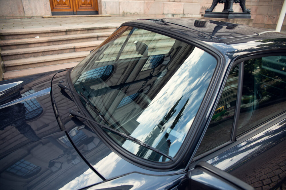 Shiny black car parked near stone steps