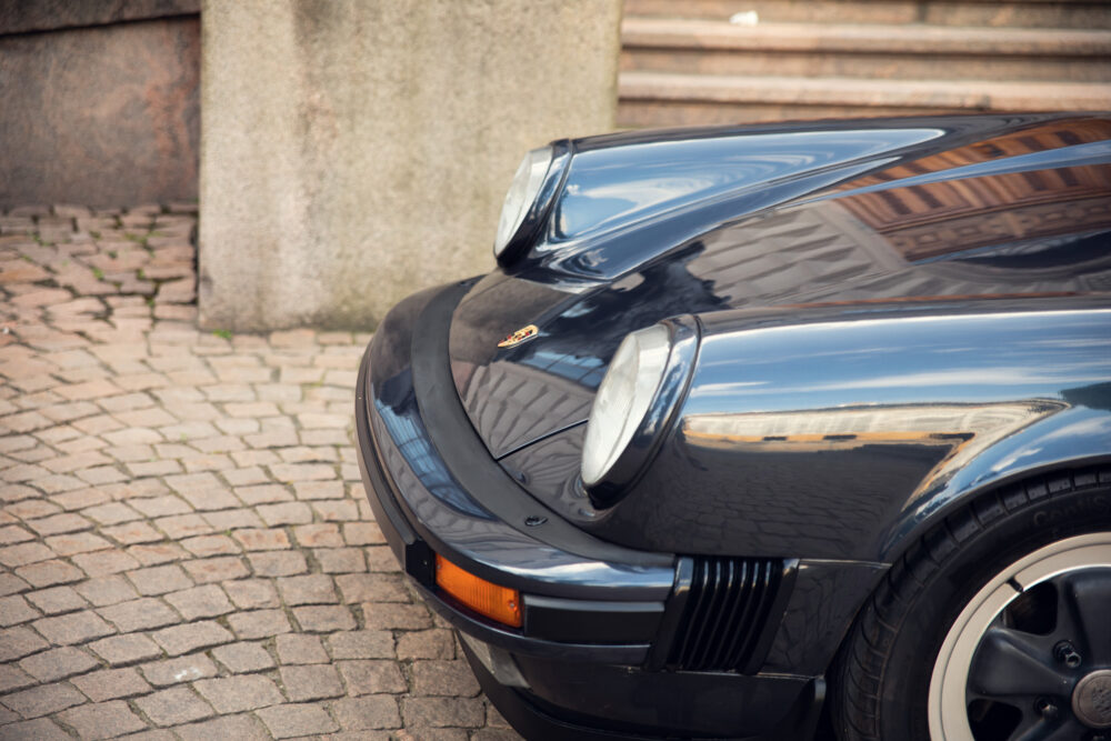Close-up of a classic black Porsche on cobblestone