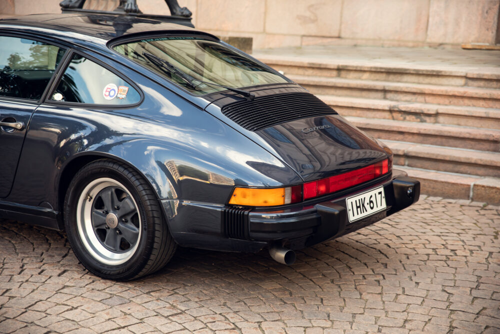 Vintage Porsche 911 Carrera parked on cobblestone street