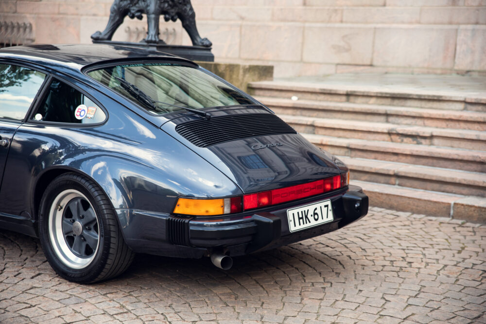 Classic Porsche Carrera on cobblestone near steps