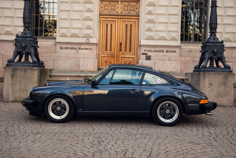 Classic black Porsche parked outside Finland's Bank building