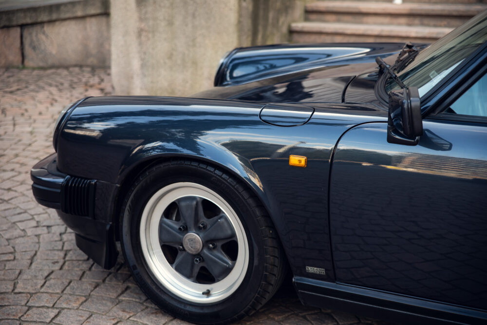 Close-up of classic black sports car on cobblestone
