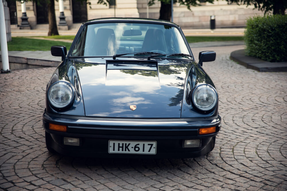 Vintage black Porsche car on cobblestone street