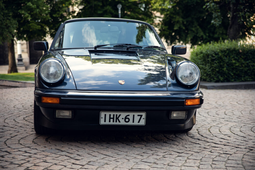 Vintage Porsche car parked on cobblestone street