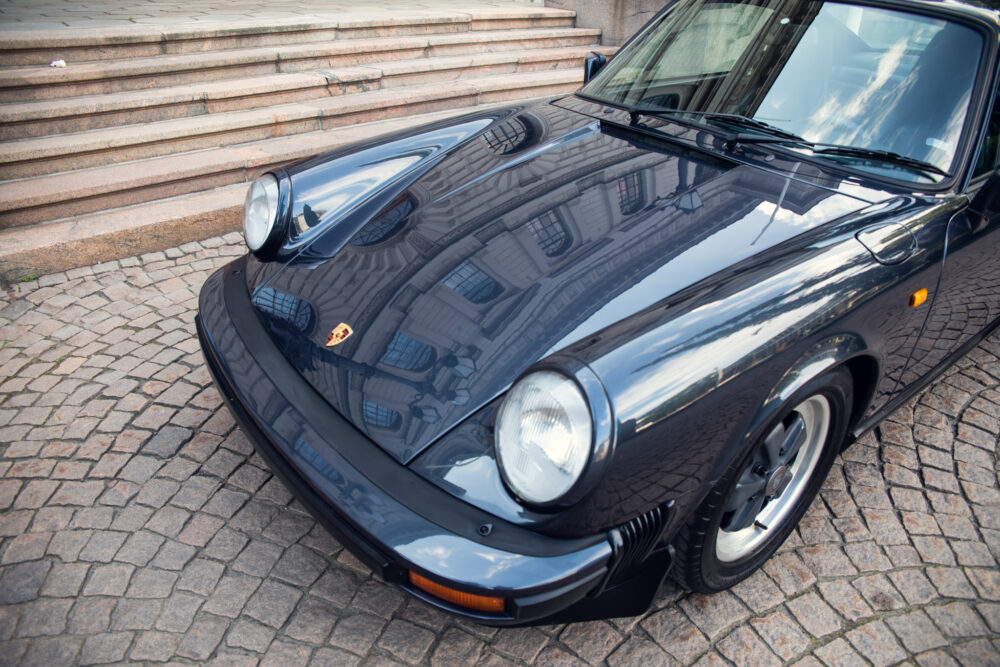 Vintage Porsche car parked on cobblestone street