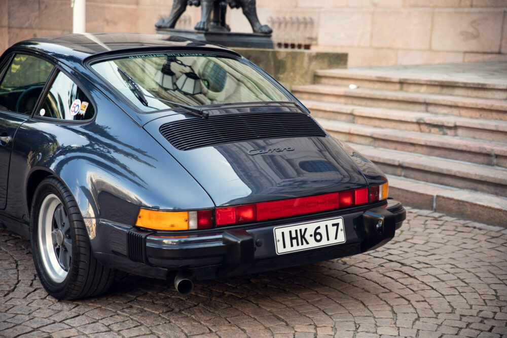Vintage Porsche 911 Carrera parked on cobblestone street