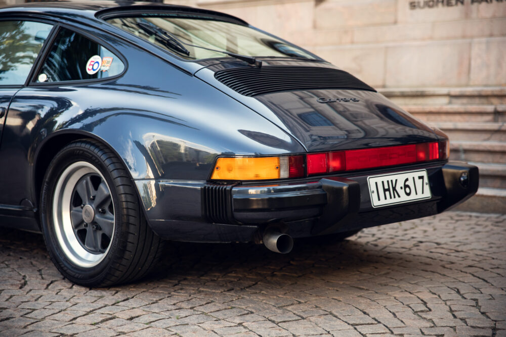 Classic black Porsche Carrera rear view on cobblestone