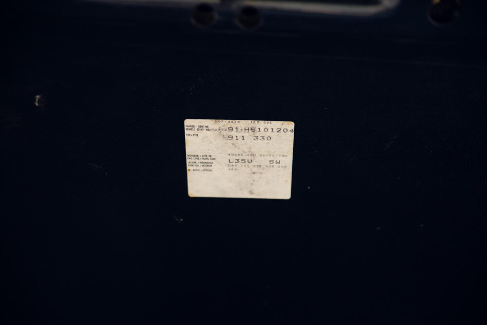Faded vehicle identification label on dark surface