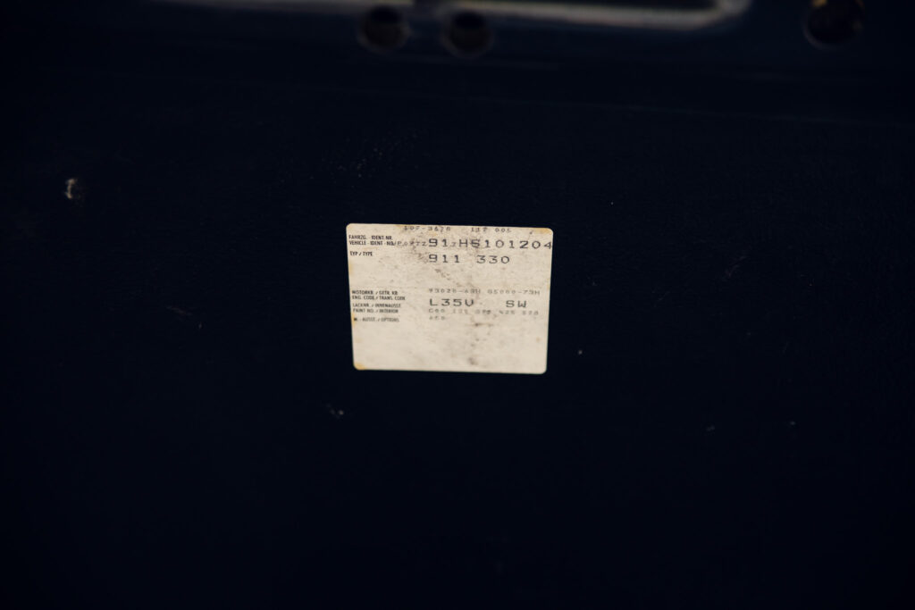 Faded vehicle identification label on dark surface