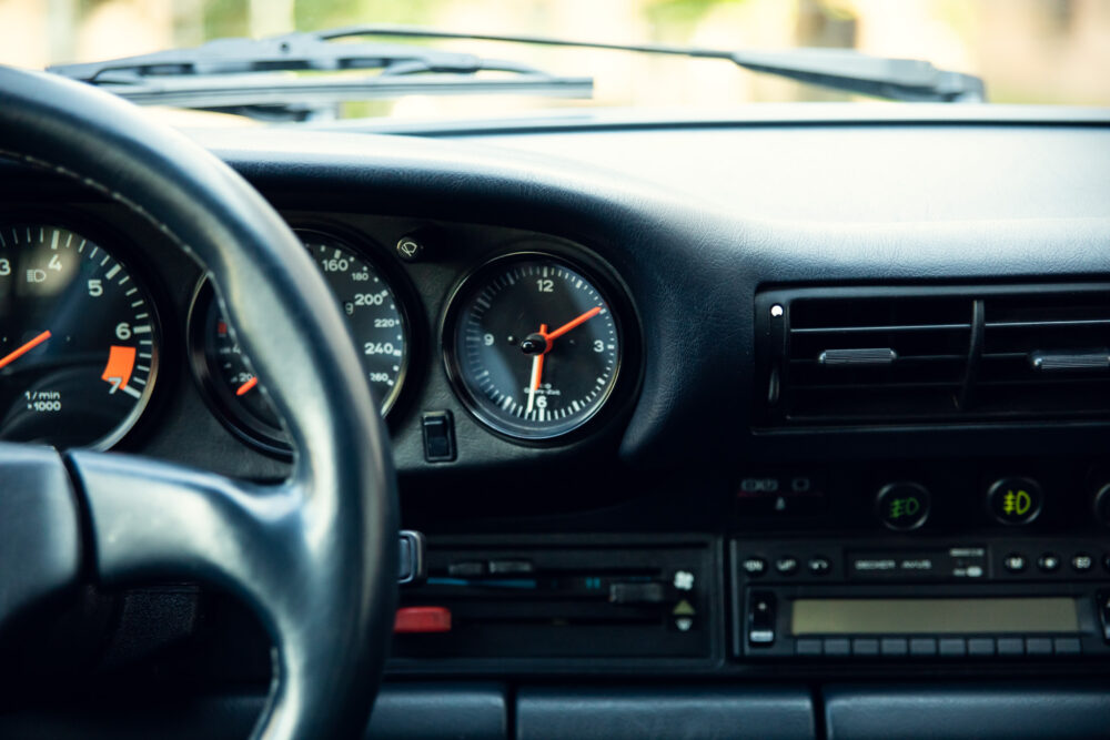 Close-up of car dashboard with gauges and controls.