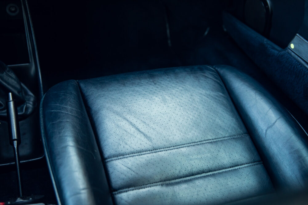Close-up of worn blue leather car seat