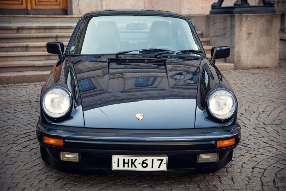 Classic black Porsche parked in front of a building
