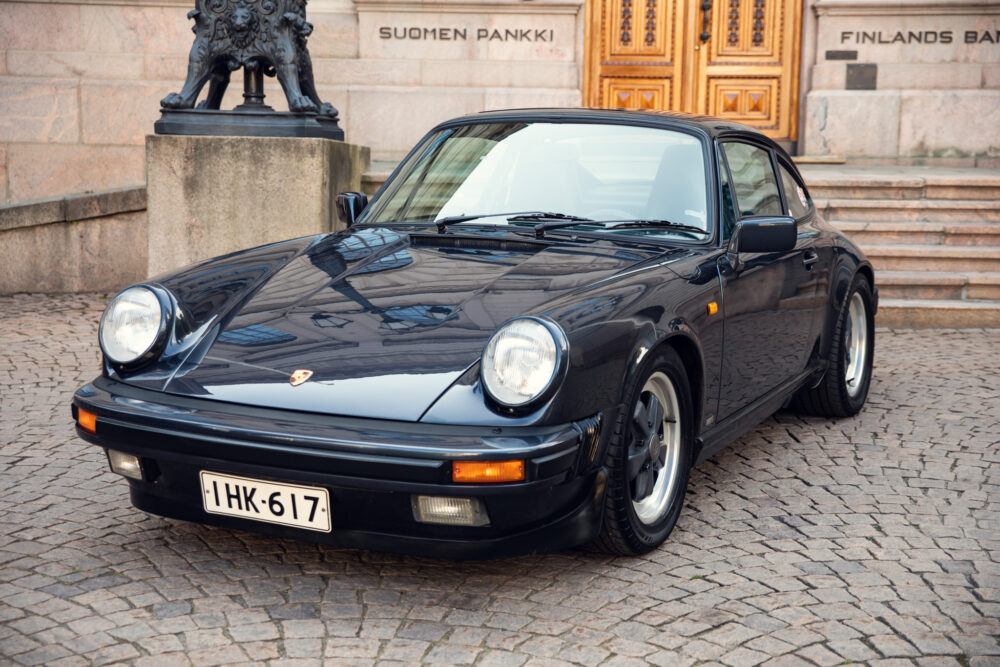 Vintage black Porsche in front of historic building