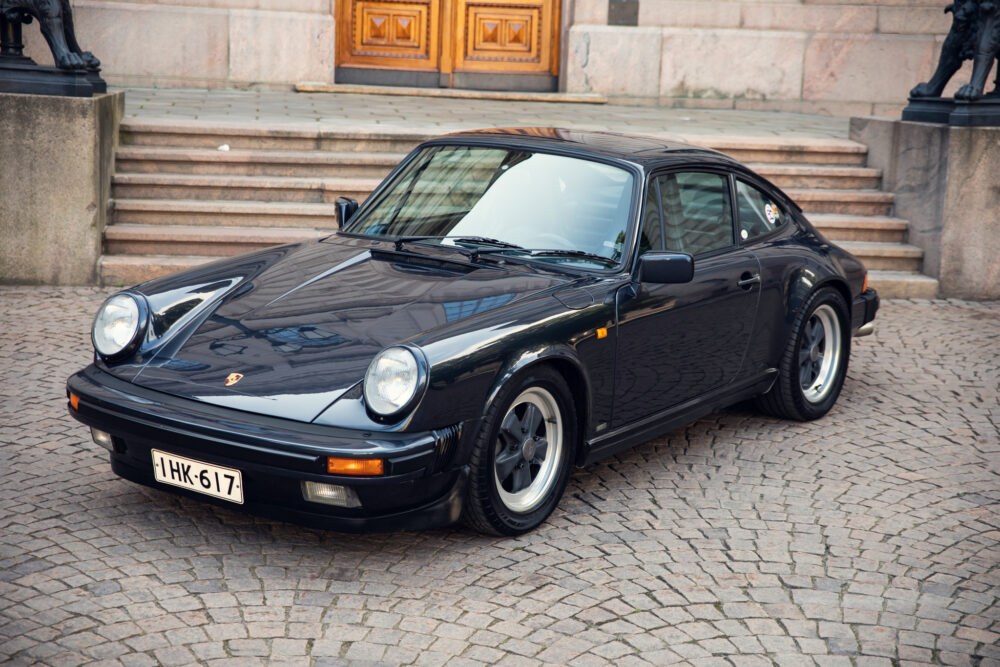 Vintage black Porsche 911 parked near stone steps