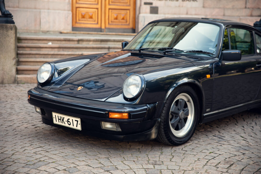 Vintage black Porsche car parked near historic building