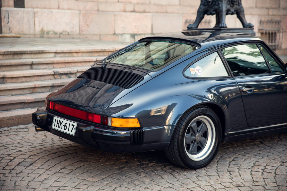 Vintage Porsche 911 Carrera parked near steps