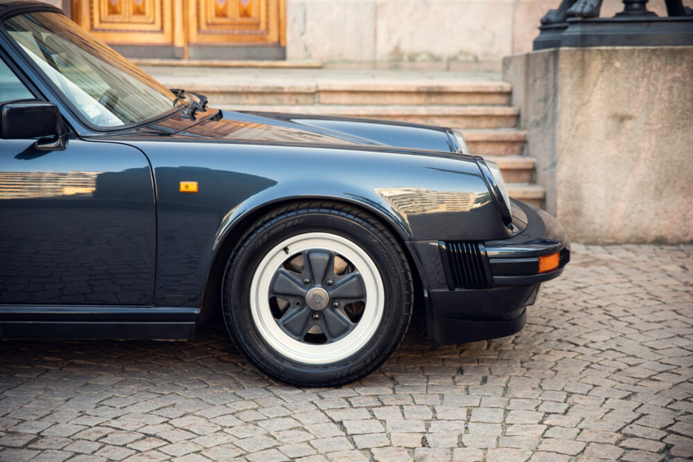 Vintage black sports car parked near historic building