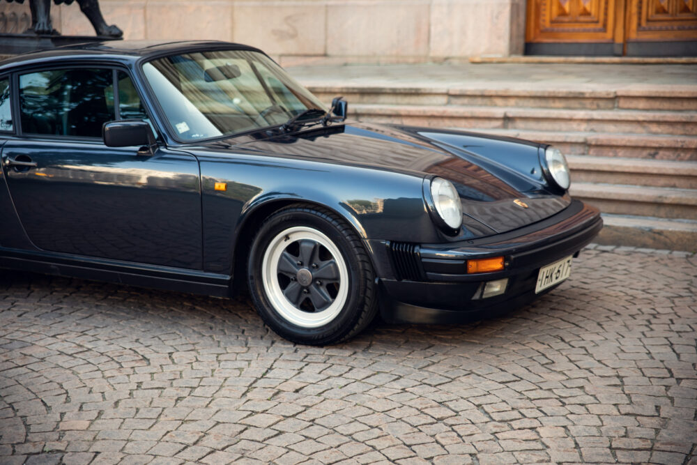 Classic black Porsche on cobblestone street