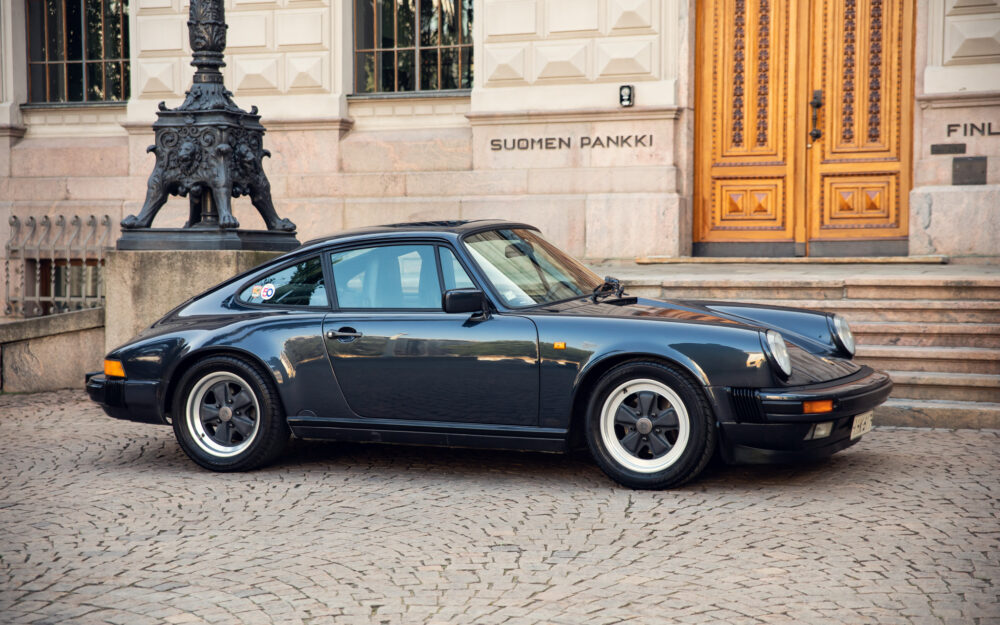 Classic black Porsche in front of Finland Bank building