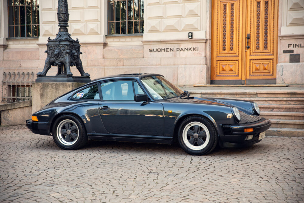 Classic black Porsche in front of Finland Bank building