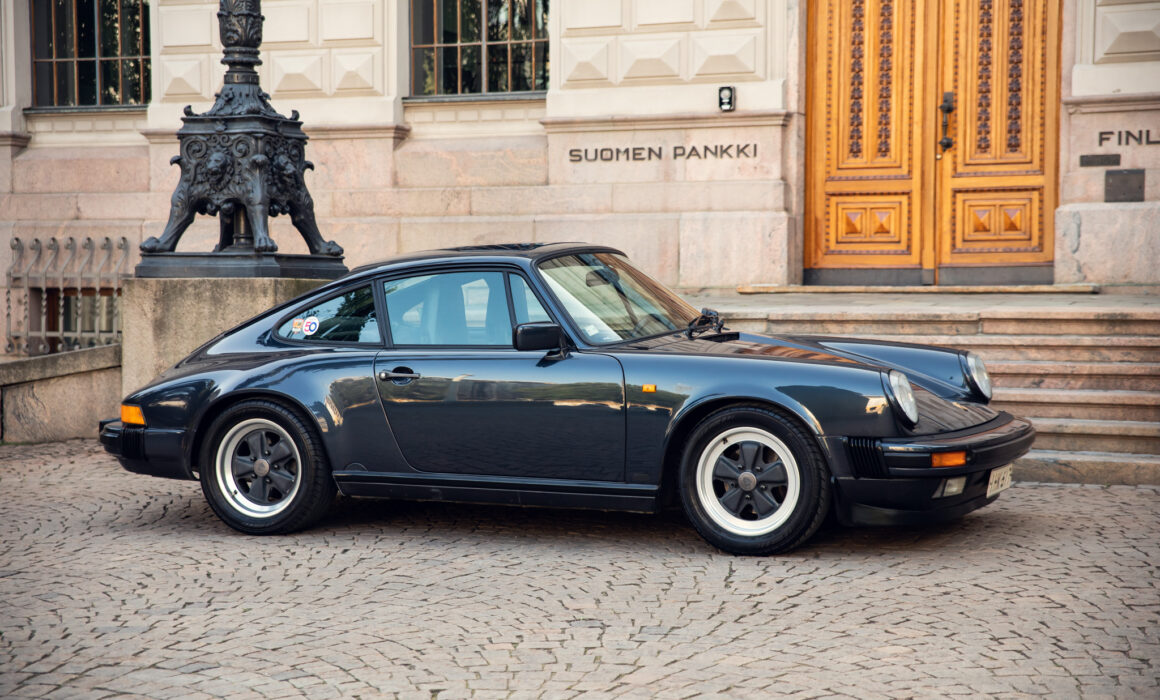 Classic black Porsche in front of Finland Bank building