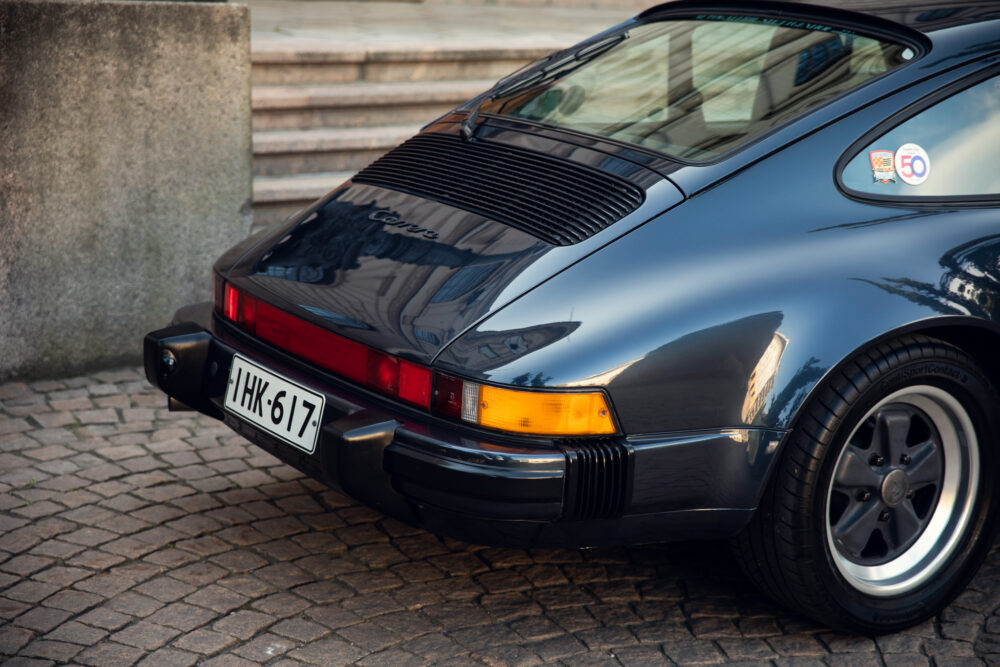 Vintage Porsche Carrera car parked by stone steps
