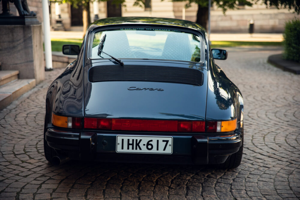 Vintage Porsche Carrera parked on cobblestone street