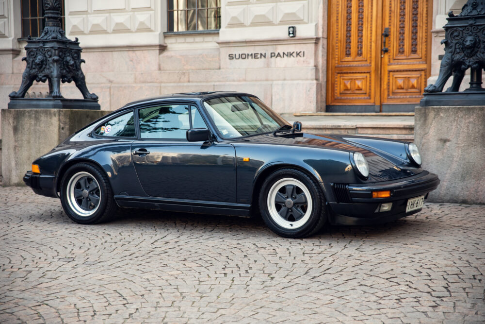 Vintage black Porsche parked near historical building
