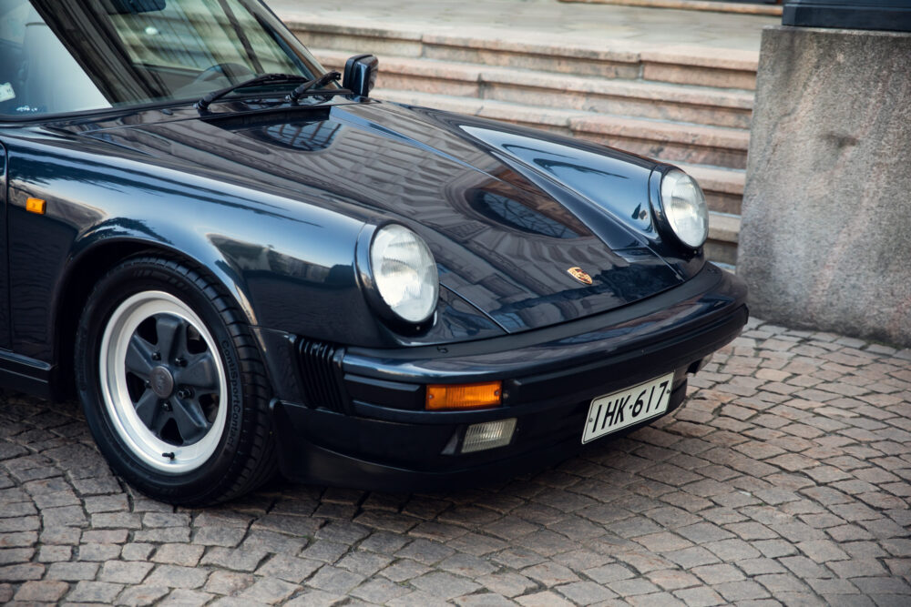 Vintage black Porsche car on cobblestone street