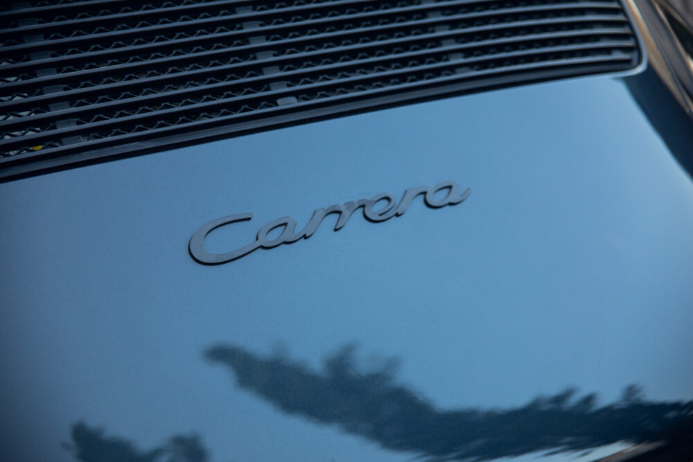 Close-up of 'Carrera' badge on blue car