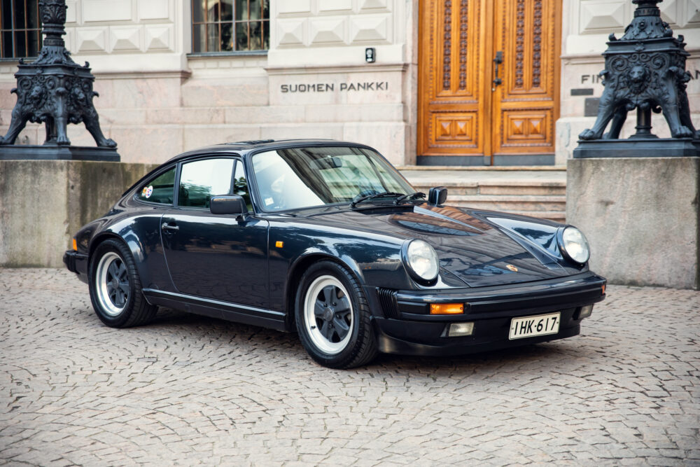 Vintage black Porsche parked near ornate building