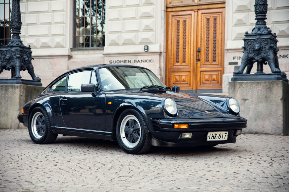 Vintage black Porsche in front of historic building