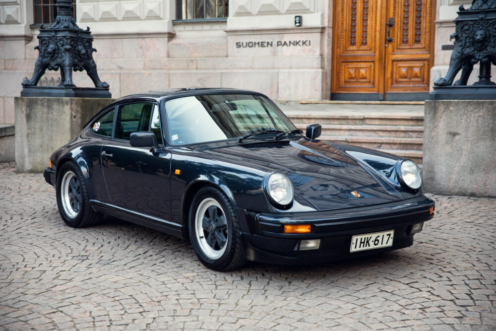 Vintage Porsche 911 parked in front of building