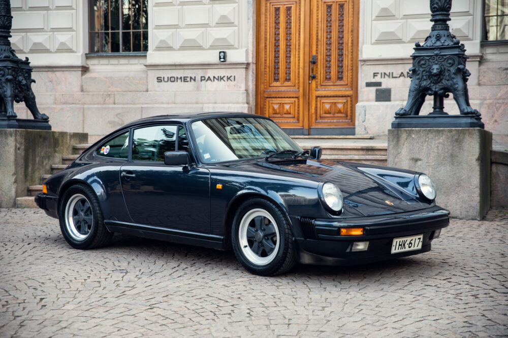 Vintage black Porsche 911 outside elegant building