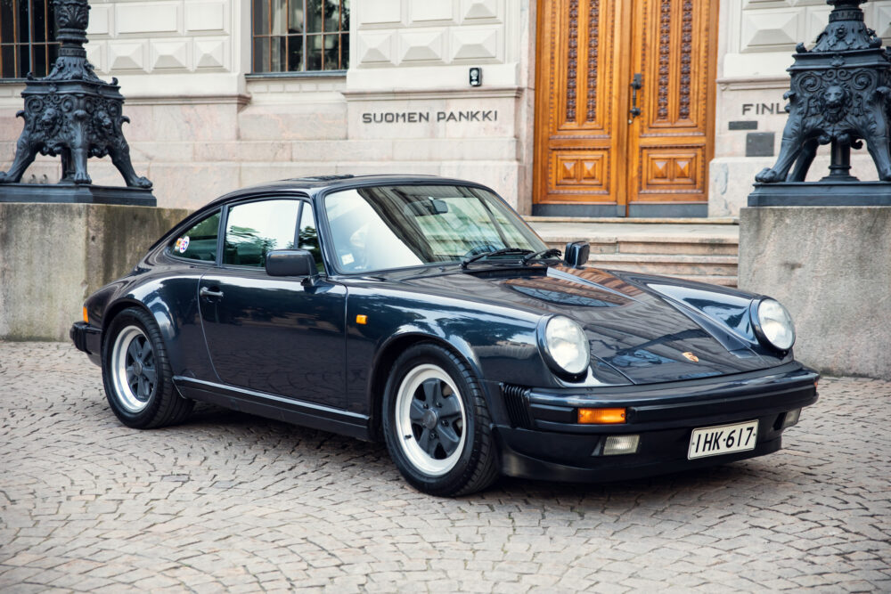 Vintage black Porsche parked near historic building