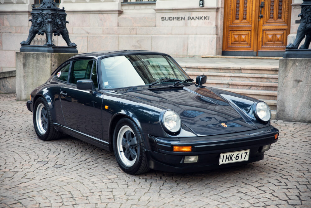 Classic black Porsche 911 parked near historical building