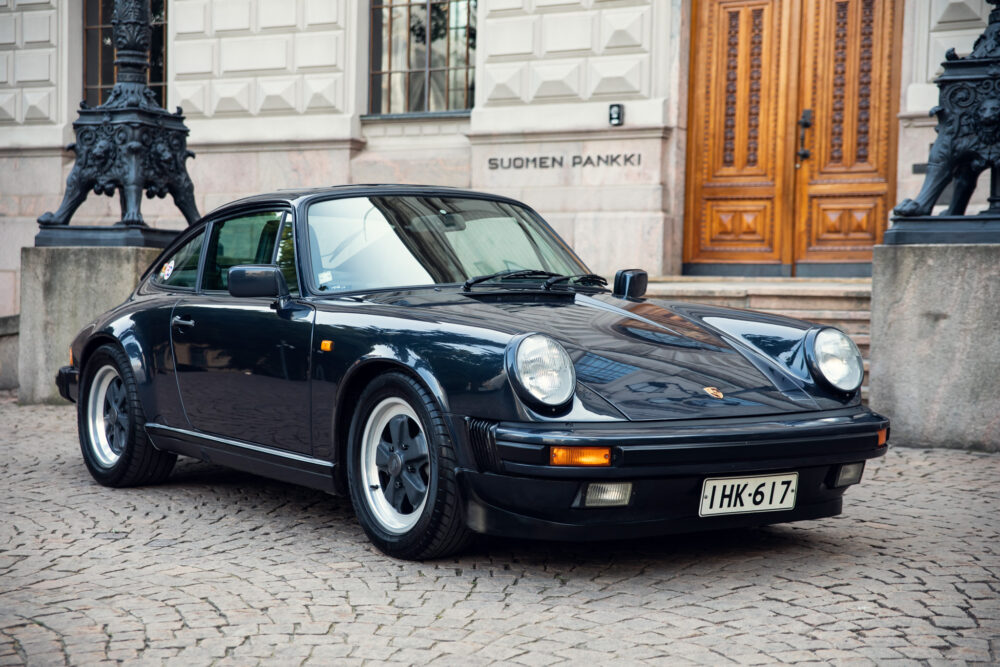 Classic black Porsche car in front of ornate building