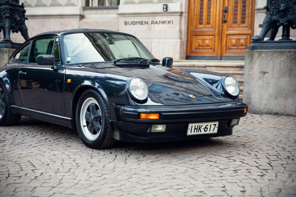 Vintage Porsche 911 parked outside a historic building