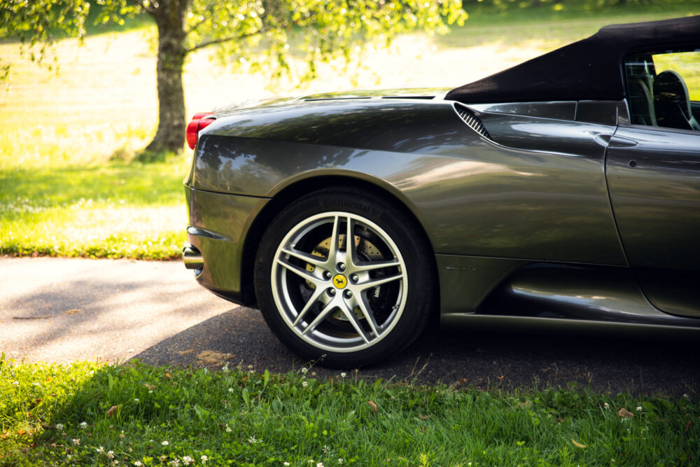 Green convertible sports car in sunny park setting