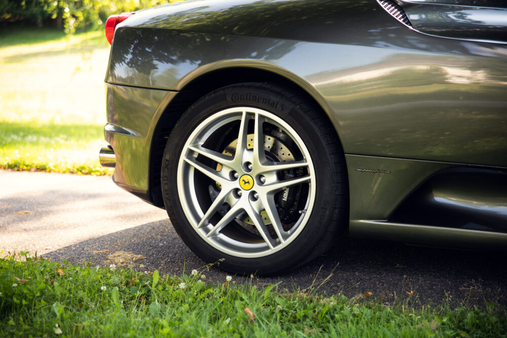 Green Ferrari rear wheel and logo on sunny day