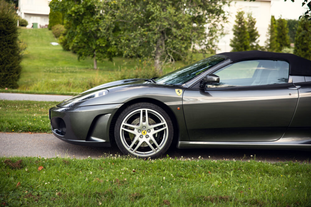 Gray Ferrari convertible on roadside grass