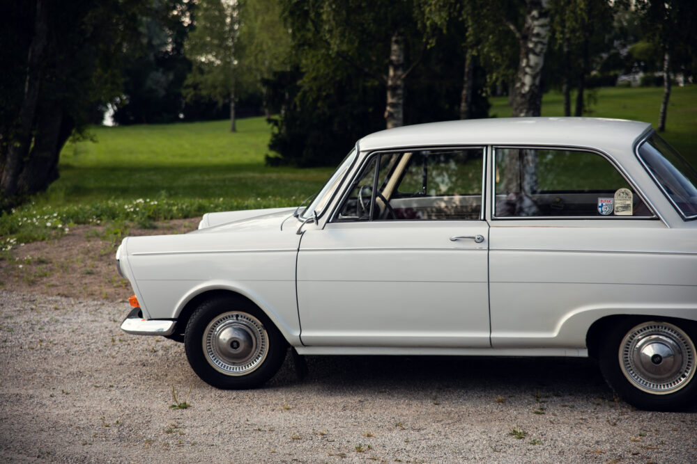 Vintage white car parked in lush green park
