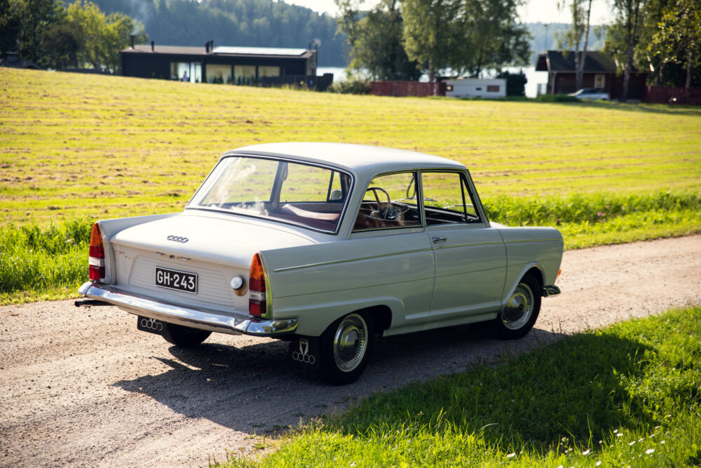 Vintage Audi parked on rural roadside near lake