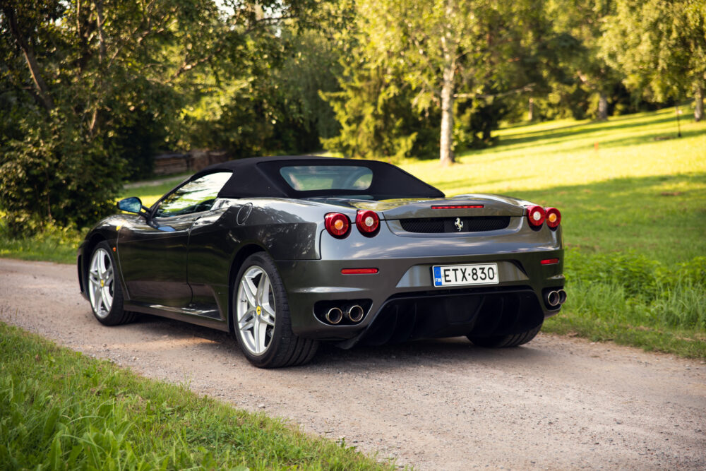 Black Ferrari parked on scenic forest road