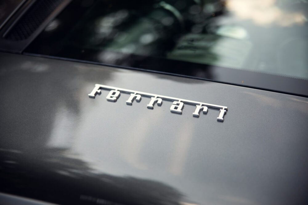 Close-up of Ferrari logo on gray car hood