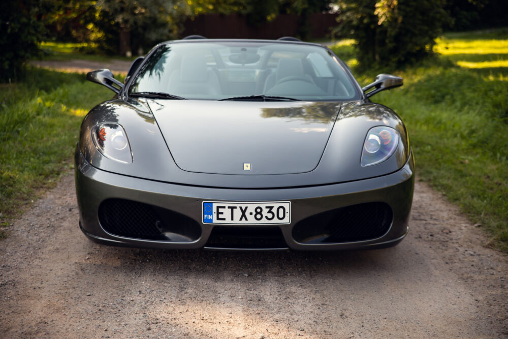 Silver sports car parked on a forest pathway