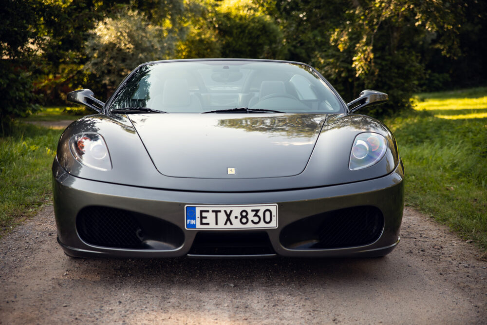 Silver Ferrari F430 on a serene forest path