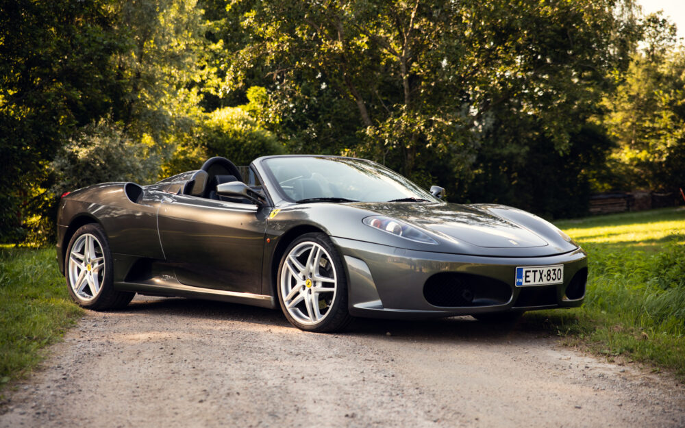Silver convertible sports car parked on forest road