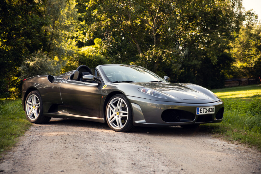 Silver convertible sports car parked on forest road